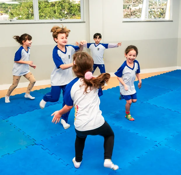 Alunos praticando esporte na quadra da escola